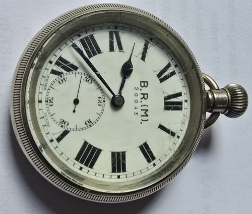 fig 1. A British Rail Midland Region open-face pocket watch featuring a white dial with Roman numerals, spade hands, and a subsidiary seconds subdial.