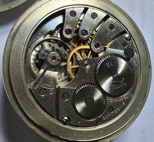 fig 9. A British Rail Midland Region open-face pocket watch featuring a white dial with Roman numerals, spade hands, and a subsidiary seconds subdial.