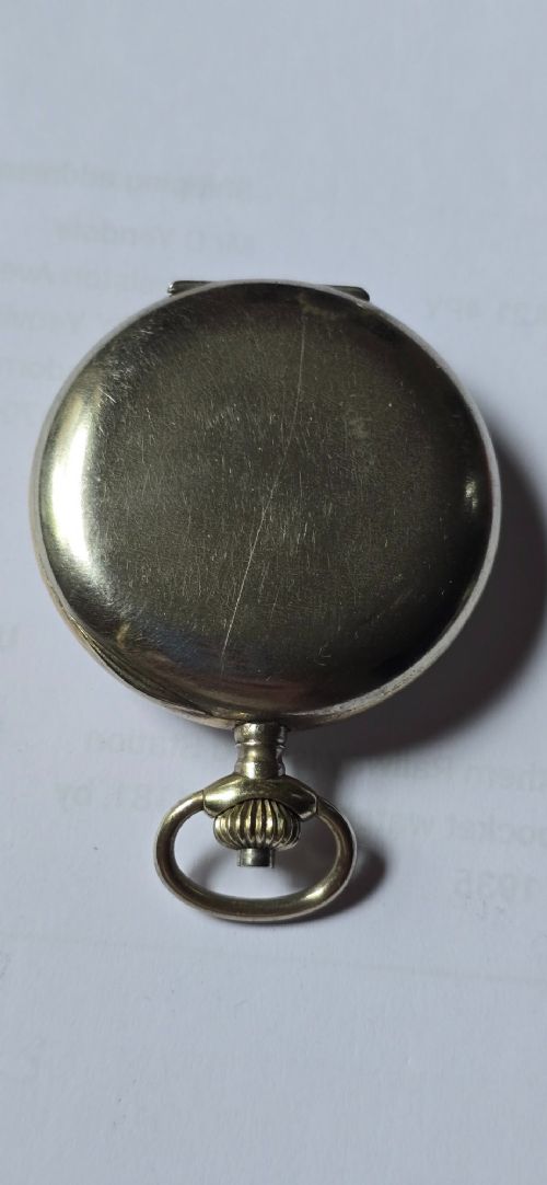 fig 4. An open-face military pocket watch chronograph featuring a white enamel dial with black Arabic numerals, dual sub-dials, and French military markings enclosed in a round silver case.