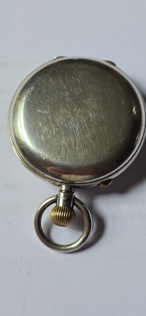 fig 3. An open-face silver pocket watch featuring a white enamel dial with black Roman numerals, split-seconds hands, a subsidiary seconds dial, and a brass onion crown at the top.