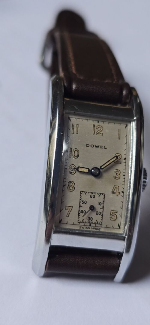 A 1940s rectangular gents mechanical tank watch with a silver-tone case, cream dial featuring printed Arabic numerals and a sub-seconds dial, finished with a brown leather strap. View XIV