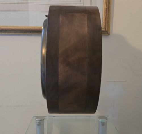 fig 4. An arched wooden mantel clock featuring a white dial with Roman numerals, a brass bezel, and British Rail markings.
