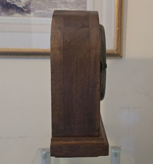 fig 5. An arched wooden mantel clock featuring a white dial with Roman numerals, a brass bezel, and British Rail markings.