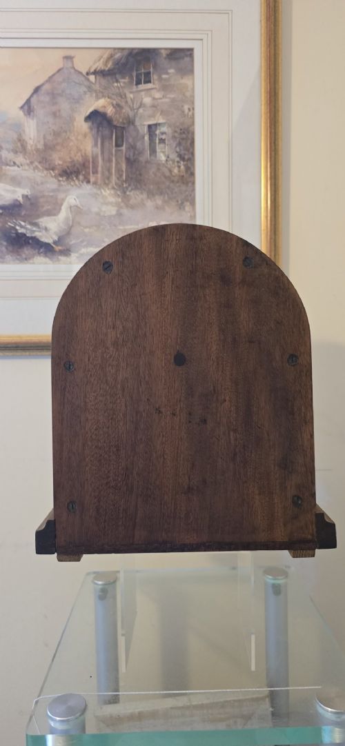 fig 6. An arched wooden mantel clock featuring a white dial with Roman numerals, a brass bezel, and British Rail markings.