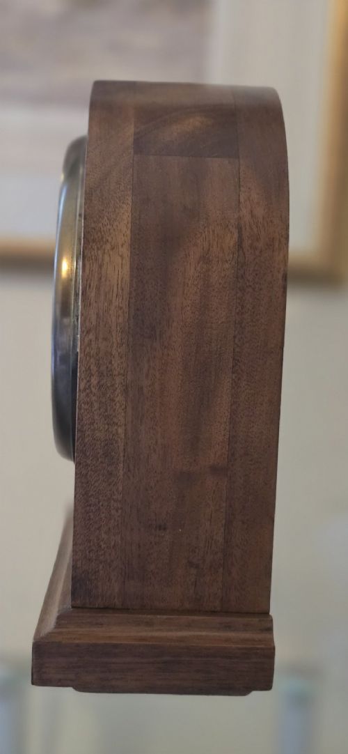 fig 7. An arched wooden mantel clock featuring a white dial with Roman numerals, a brass bezel, and British Rail markings.
