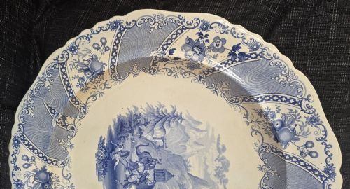 fig 4. An antique circular earthenware plate featuring a blue transfer-printed central scene of Hannibal with an elephant and figures in a mountainous landscape, surrounded by an ornate scalloped floral border.