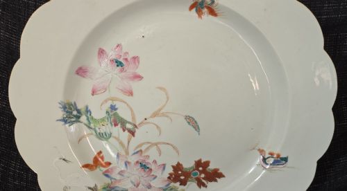 fig 3. An antique circular off-white porcelain dish with a scalloped rim, hand-painted with pink lotus blossoms, foliage, a crane, and a waterfowl.