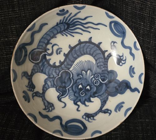 fig 4. An eighteenth-century circular English delftware saucer dish painted with a cobalt blue dragon motif on a white tin glaze.