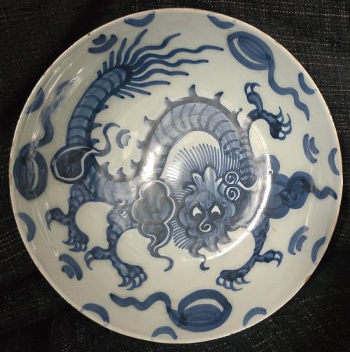 fig 5. An eighteenth-century circular English delftware saucer dish painted with a cobalt blue dragon motif on a white tin glaze.