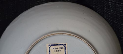 fig 6. An eighteenth-century circular English delftware saucer dish painted with a cobalt blue dragon motif on a white tin glaze.
