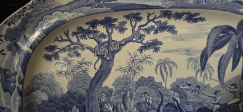fig 5. An oval blue and white underglaze transfer-printed earthenware meat platter depicting a landscape with hunters on elephants and hounds pursuing a leopard.