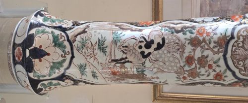 fig 1. A tall Japanese Imari porcelain trumpet vase featuring hand-painted designs of horses, floral panels, and geometric borders in blue, iron red, and enamels.