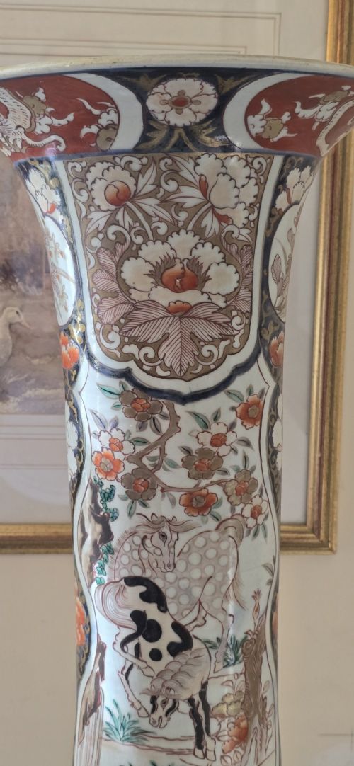 fig 3. A tall Japanese Imari porcelain trumpet vase featuring hand-painted designs of horses, floral panels, and geometric borders in blue, iron red, and enamels.