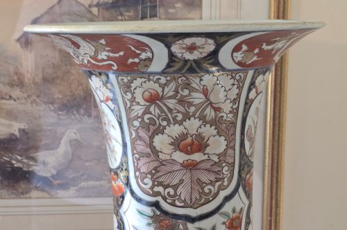 fig 4. A tall Japanese Imari porcelain trumpet vase featuring hand-painted designs of horses, floral panels, and geometric borders in blue, iron red, and enamels.