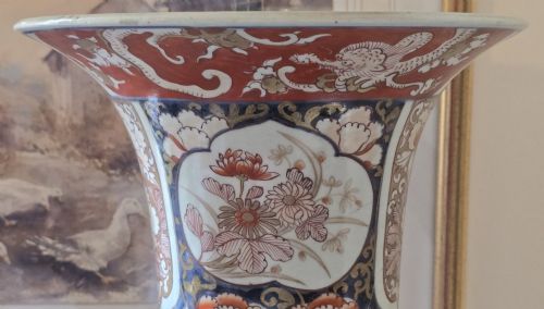 fig 5. A tall Japanese Imari porcelain trumpet vase featuring hand-painted designs of horses, floral panels, and geometric borders in blue, iron red, and enamels.