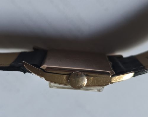 fig 4. A vintage Longines rectangular wristwatch featuring a rose gold-filled case, patinated dial with Arabic numerals, sub-seconds register, and a black leather strap.