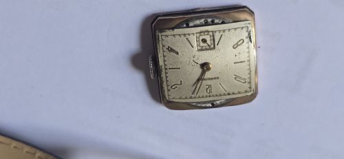 fig 7. A vintage Longines rectangular wristwatch featuring a rose gold-filled case, patinated dial with Arabic numerals, sub-seconds register, and a black leather strap.