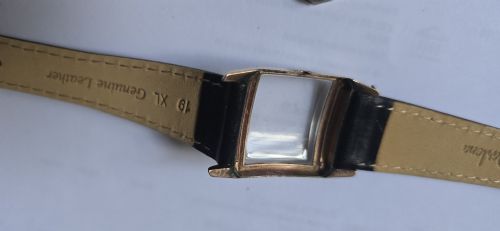 fig 8. A vintage Longines rectangular wristwatch featuring a rose gold-filled case, patinated dial with Arabic numerals, sub-seconds register, and a black leather strap.