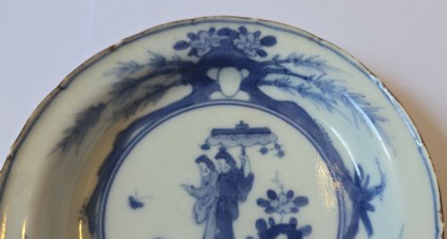 fig 3. A circular Edo period Japanese Arita porcelain shallow dish featuring hand-painted cobalt blue underglaze figurative and floral decoration on an off-white ceramic body.