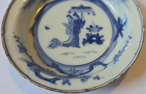 fig 4. A circular Edo period Japanese Arita porcelain shallow dish featuring hand-painted cobalt blue underglaze figurative and floral decoration on an off-white ceramic body.