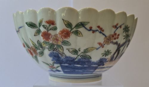 fig 1. A fluted late 17th-century Japanese porcelain bowl decorated with polychrome floral enamel motifs against an off-white background.