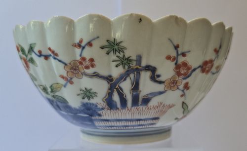 fig 2. A fluted late 17th-century Japanese porcelain bowl decorated with polychrome floral enamel motifs against an off-white background.