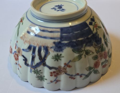 fig 6. A fluted late 17th-century Japanese porcelain bowl decorated with polychrome floral enamel motifs against an off-white background.