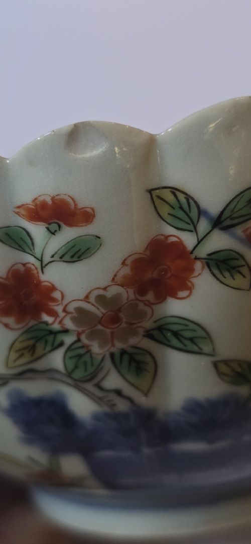 A fluted late 17th-century Japanese porcelain bowl decorated with polychrome floral enamel motifs against an off-white background. View XII