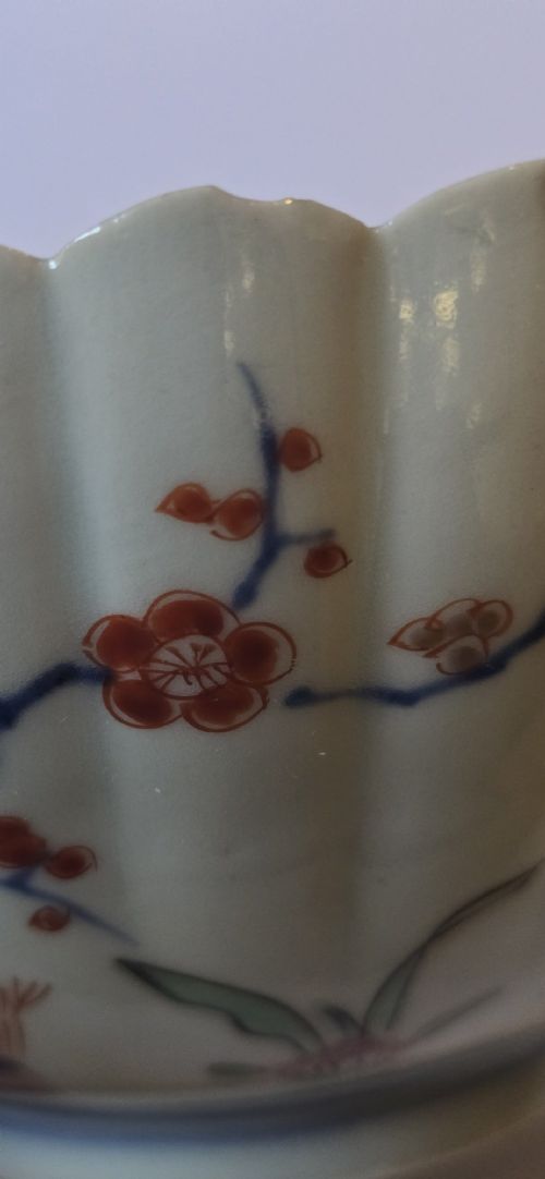 A fluted late 17th-century Japanese porcelain bowl decorated with polychrome floral enamel motifs against an off-white background. View XV