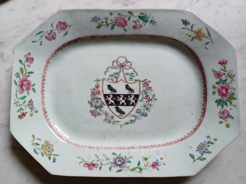 An 18th-century octagonal Chinese porcelain dish decorated with a central heraldic crest and colourful floral enamel sprays along the border.