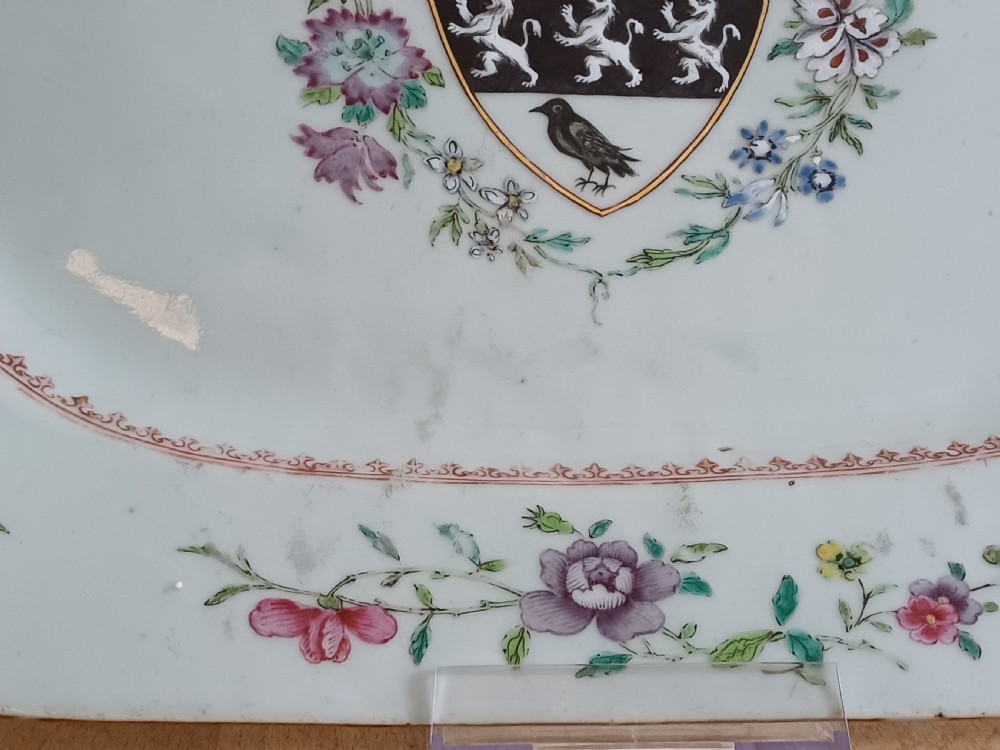 An 18th-century octagonal Chinese porcelain dish decorated with a central heraldic crest and colourful floral enamel sprays along the border. View XV