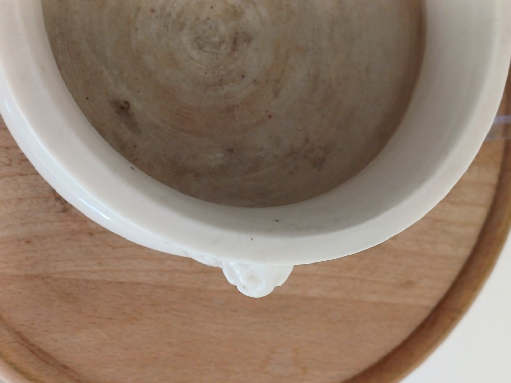 A small round ivory white glazed porcelain censer featuring moulded mask handles on either side and a short flared foot base. View XI