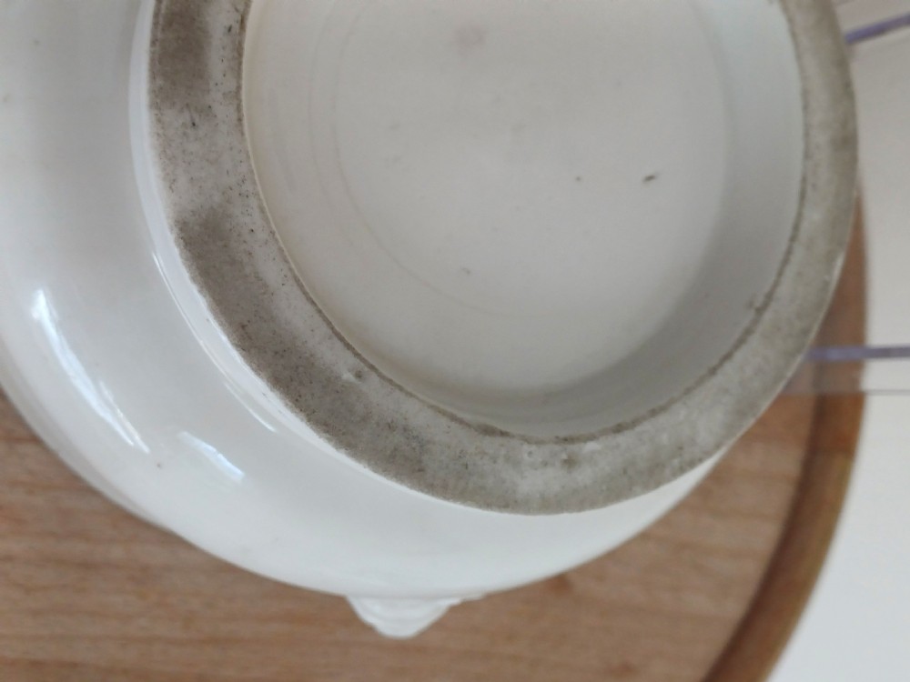 A small round ivory white glazed porcelain censer featuring moulded mask handles on either side and a short flared foot base. View XVIII