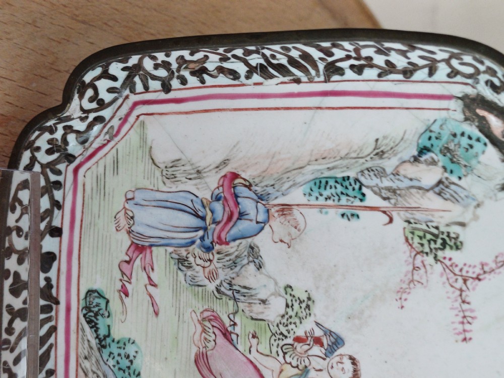 A square 18th-century Chinese Canton enamel dish with lobed corners, depicting figures in a landscape in famille rose enamels framed by a patterned border. View XII