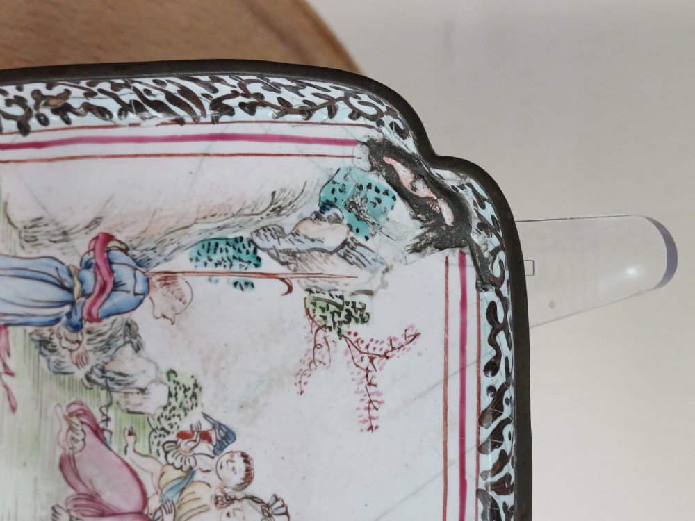 A square 18th-century Chinese Canton enamel dish with lobed corners, depicting figures in a landscape in famille rose enamels framed by a patterned border. View XIII