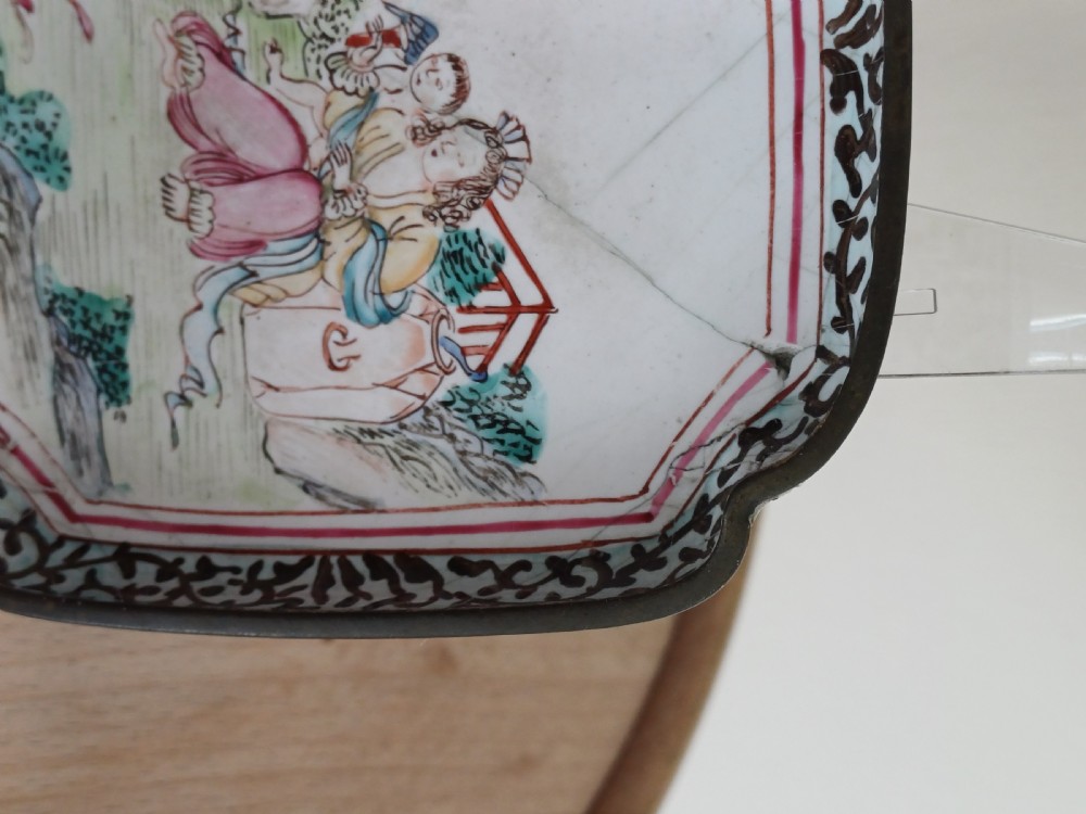 A square 18th-century Chinese Canton enamel dish with lobed corners, depicting figures in a landscape in famille rose enamels framed by a patterned border. View XIV