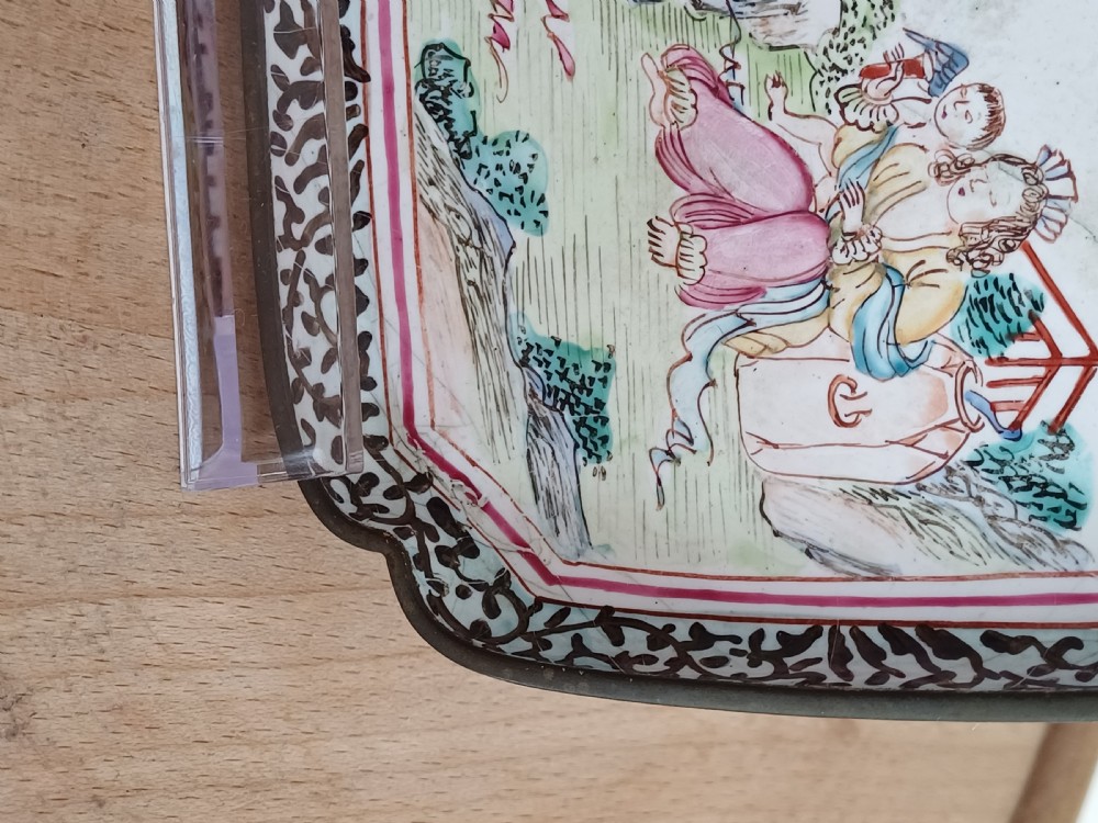 A square 18th-century Chinese Canton enamel dish with lobed corners, depicting figures in a landscape in famille rose enamels framed by a patterned border. View XV