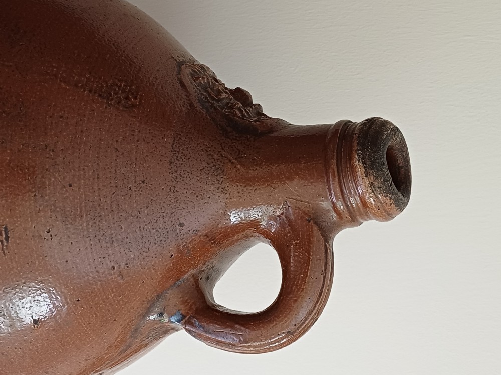 A large bulbous brown salt-glazed stoneware flagon with a narrow neck and single curved loop handle. View VI