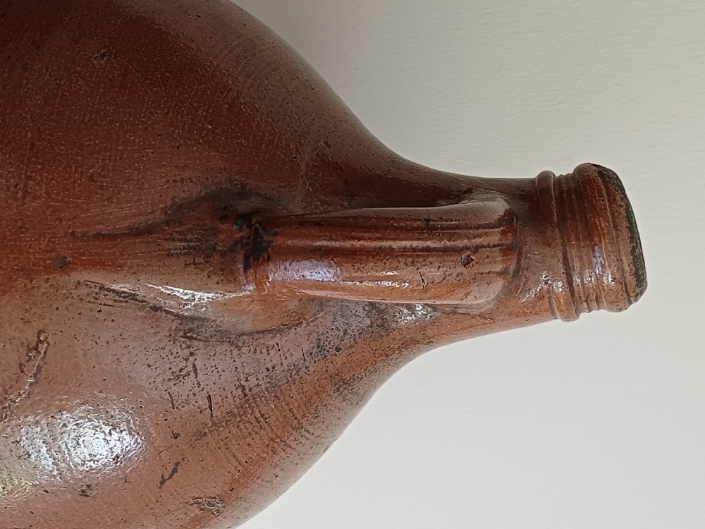 A large bulbous brown salt-glazed stoneware flagon with a narrow neck and single curved loop handle. View X