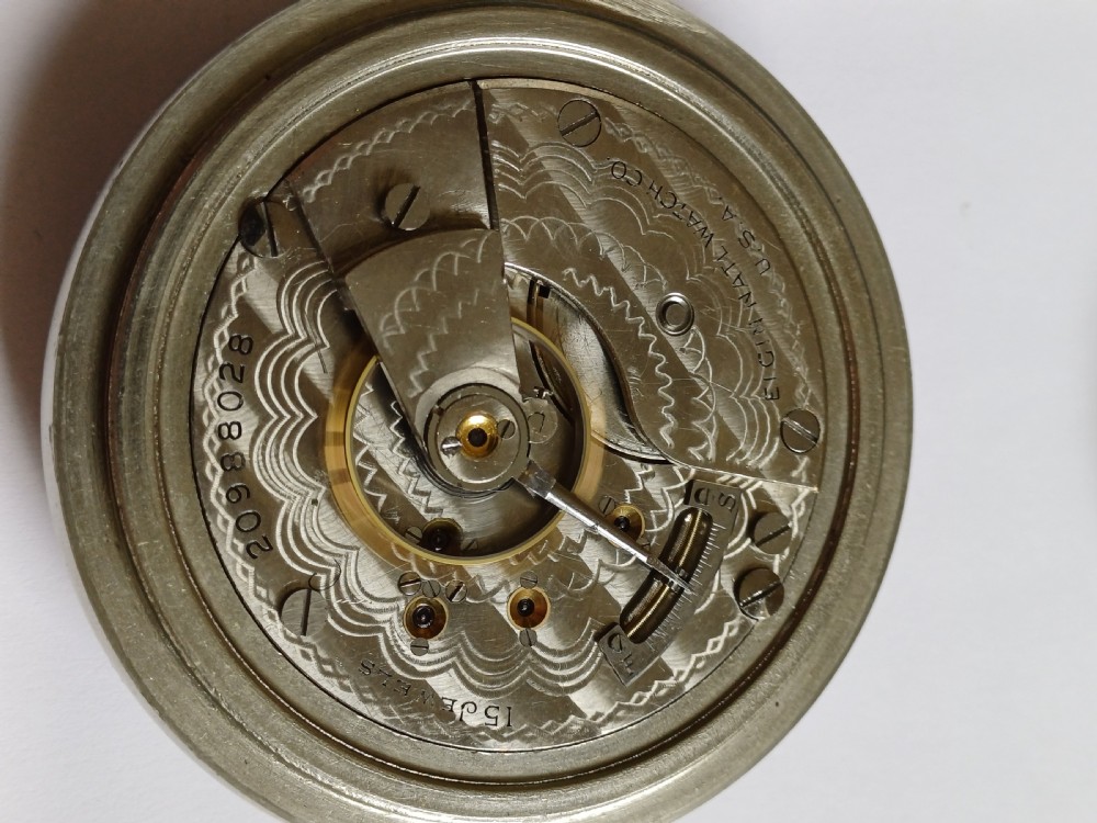 An open-face antique pocket watch featuring a white enamel dial with black Roman numerals, a sub-seconds dial, and a silver-tone nickel case. View XIV