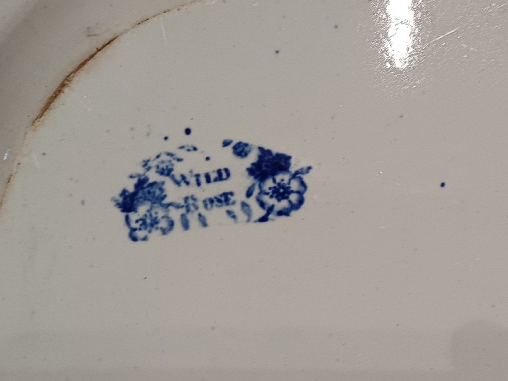 A large Victorian oval earthenware platter decorated with a cobalt blue and white transfer print featuring a pastoral river scene and a wide floral border. View X
