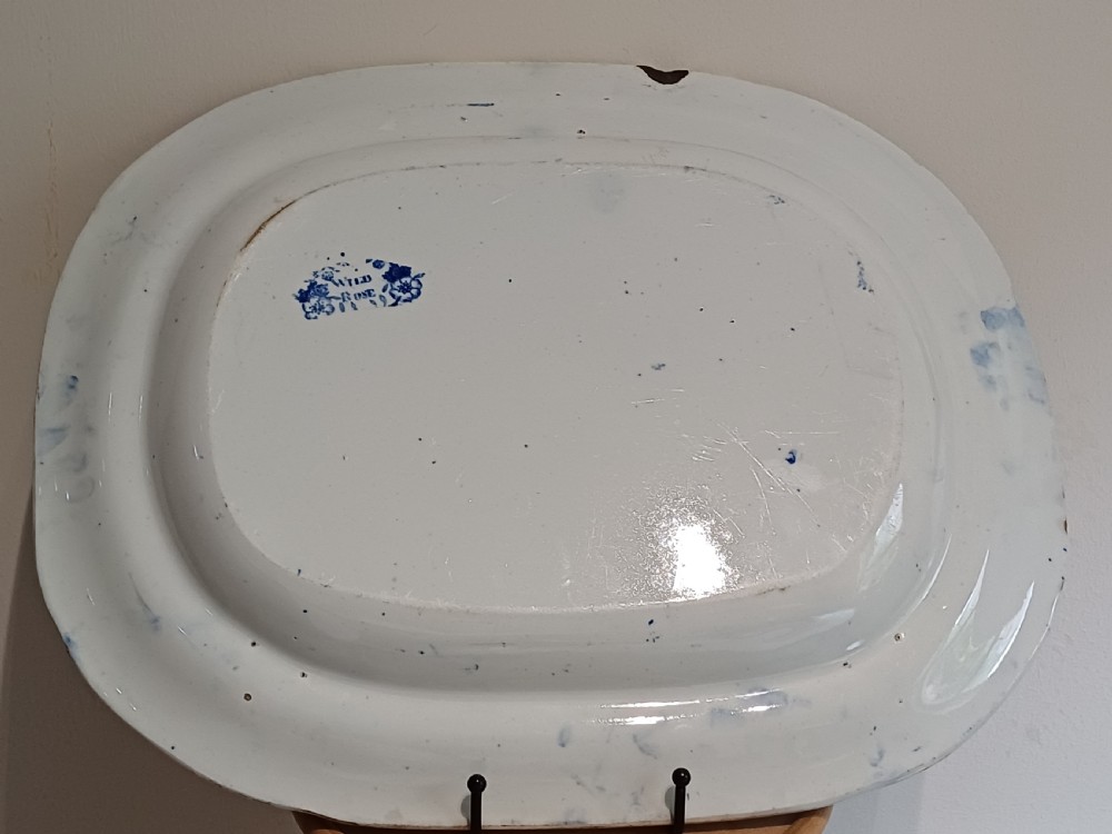 A large Victorian oval earthenware platter decorated with a cobalt blue and white transfer print featuring a pastoral river scene and a wide floral border. View XIV
