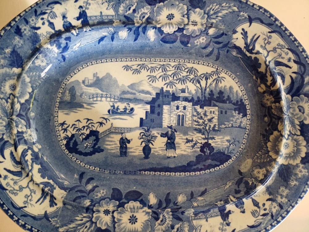 A large oval blue and white earthenware meat platter featuring a transfer-printed Chinese garden scene with figures, bridges, and floral borders. View II
