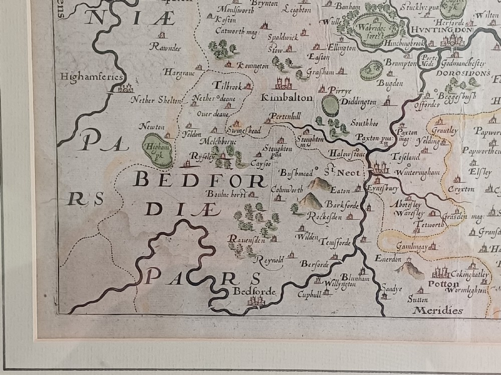 A framed 17th-century hand-coloured map of Huntingdon by Christopher Saxton set within an off-white mount and slim gilded frame. View VII