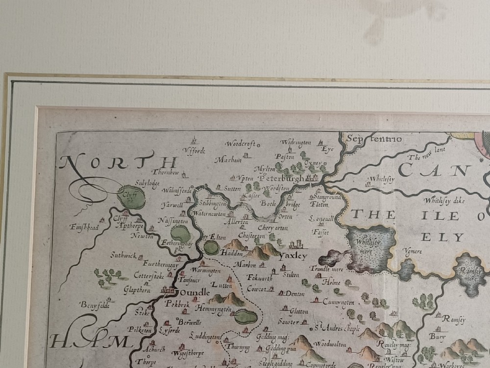 A framed 17th-century hand-coloured map of Huntingdon by Christopher Saxton set within an off-white mount and slim gilded frame. View X
