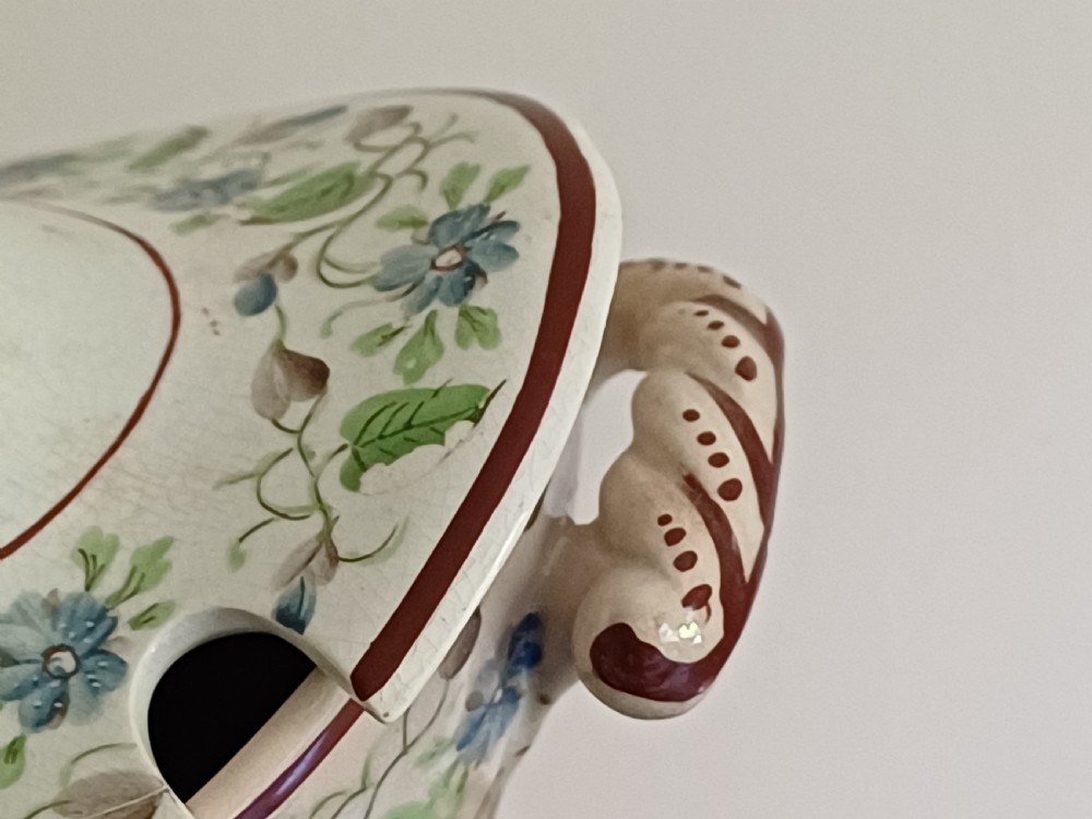 An antique cream earthenware pedestal dessert tureen with matching lid and stand, decorated with a floral vine border in blue and green. View VIII