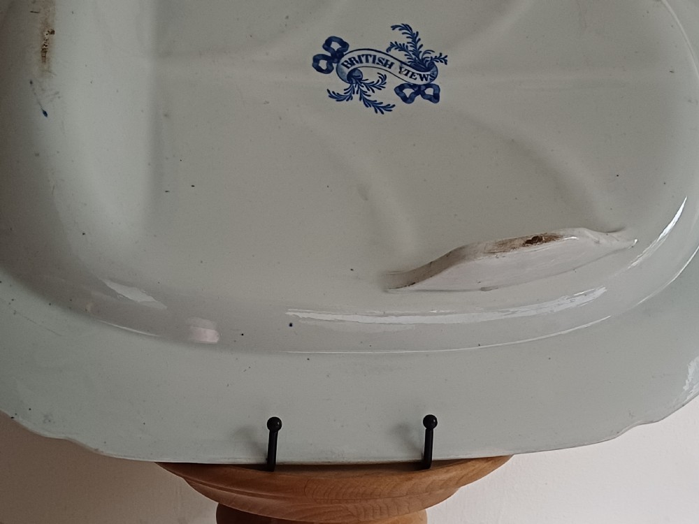 A large oval blue and white transfer printed earthenware meat platter featuring a country landscape scene with a dog and a moulded gravy well channel. View XV