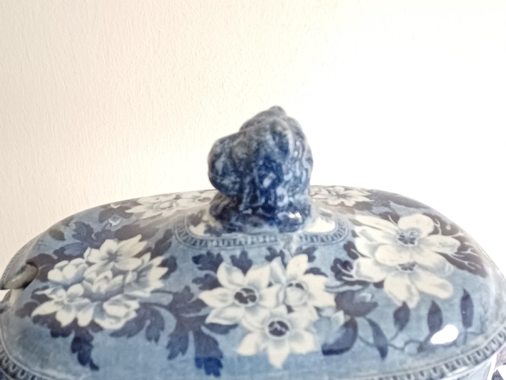 A Georgian blue and white transfer-printed ceramic sauce tureen featuring floral patterns, lion head side handles, a lion finial lid, and a matching underplate. View III