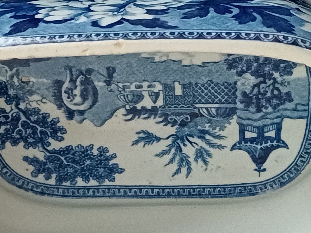 A Georgian blue and white transfer-printed ceramic sauce tureen featuring floral patterns, lion head side handles, a lion finial lid, and a matching underplate. View VII