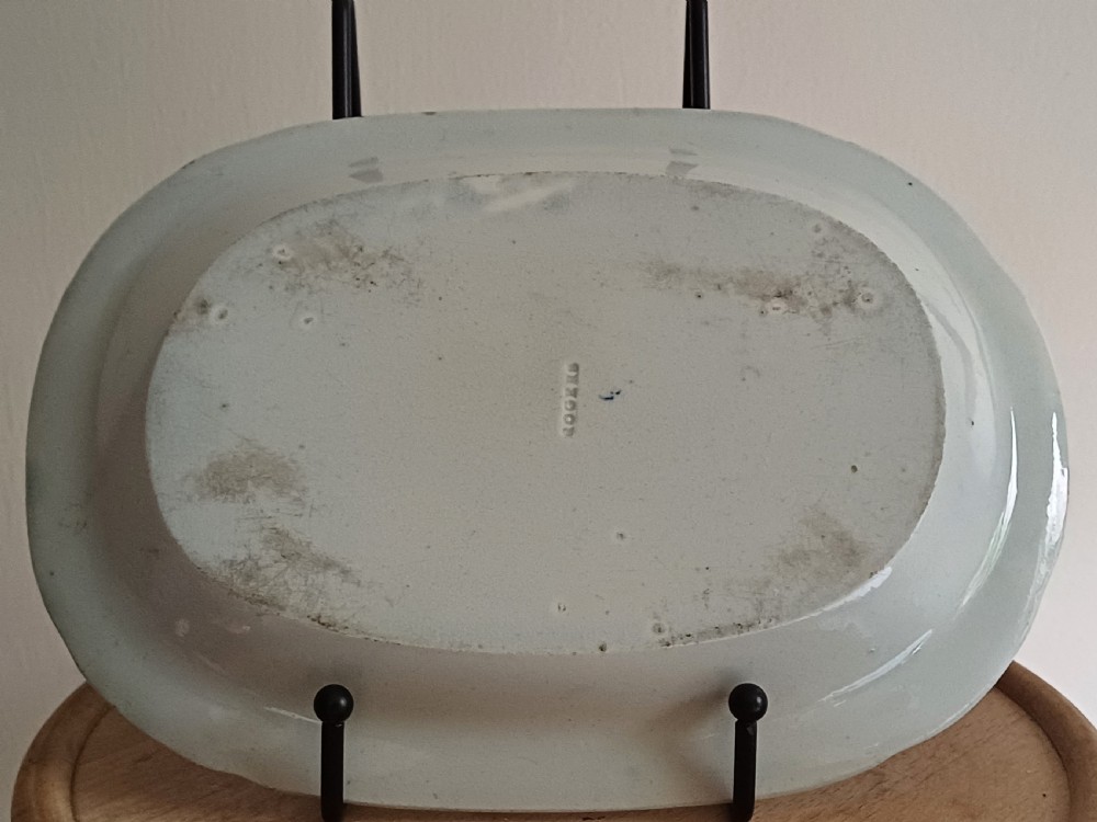 A Georgian blue and white transfer-printed ceramic sauce tureen featuring floral patterns, lion head side handles, a lion finial lid, and a matching underplate. View X